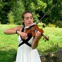 a girl in a white dress playing the violin