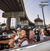 a group of men in a convertible driving over a bridge