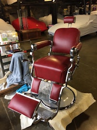 a red barber chair sitting in a room
