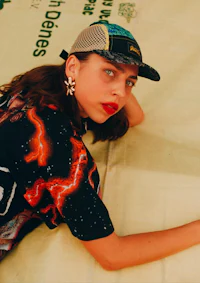 a girl laying on a blanket with a hat on her head