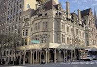 an ornate building on the corner of a city street