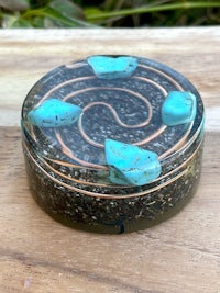 a small box with a turquoise stone in it