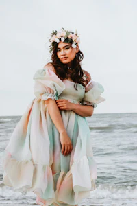 a woman in a colorful dress standing on the beach