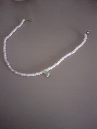 a necklace with green and white beads on it