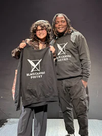 two people posing for a photo with a black hoodie