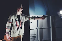 a man in a sweater holding a gun