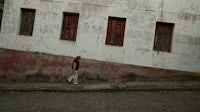a man walking down a cobblestone street