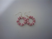 a pair of pink and white hoop earrings on a white surface