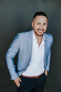 a smiling man in a blue suit posing for a photo
