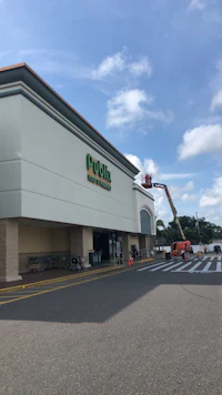 the exterior of a grocery store is being painted