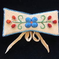 a beaded bow with red, blue, and yellow flowers