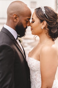 a bride and groom sharing a kiss in front of a building