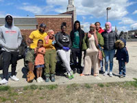 a group of people standing in front of a car