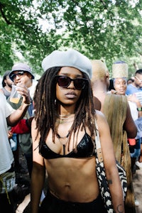 a woman in a bikini with dreadlocks standing in a crowd