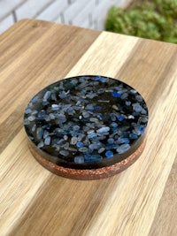 a blue stone coaster on top of a wooden table