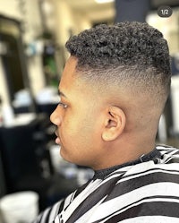 a man in a barber shop with a curly haircut