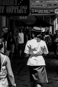 black and white photo of a woman walking down a street