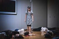 a woman is laying on the floor in front of a group of people